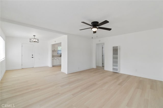 1559 N Carruth Ave, Fresno, CA 93728 - unfurnished living room featuring light wood-style floors, a heating unit, baseboards, and ceiling fan with notable chandelier