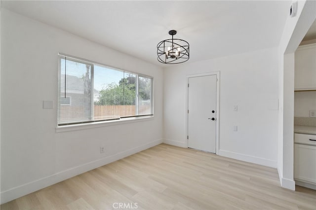 1559 N Carruth Ave, Fresno, CA 93728 - unfurnished dining area with baseboards, light wood-style flooring, and a chandelier
