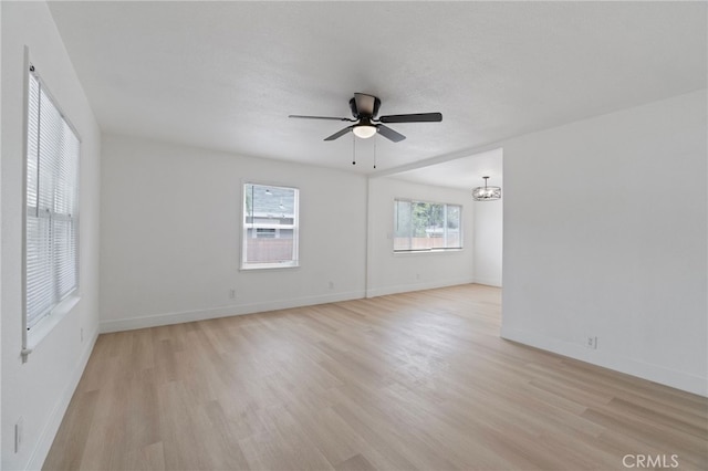1559 N Carruth Ave, Fresno, CA 93728 - spare room with baseboards, light wood finished floors, and ceiling fan with notable chandelier