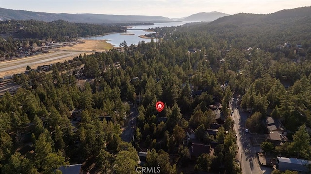 drone / aerial view with a wooded view and a water and mountain view