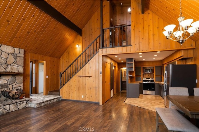 living room with wood walls, high vaulted ceiling, and a chandelier
