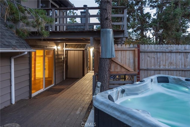 deck featuring fence and a hot tub