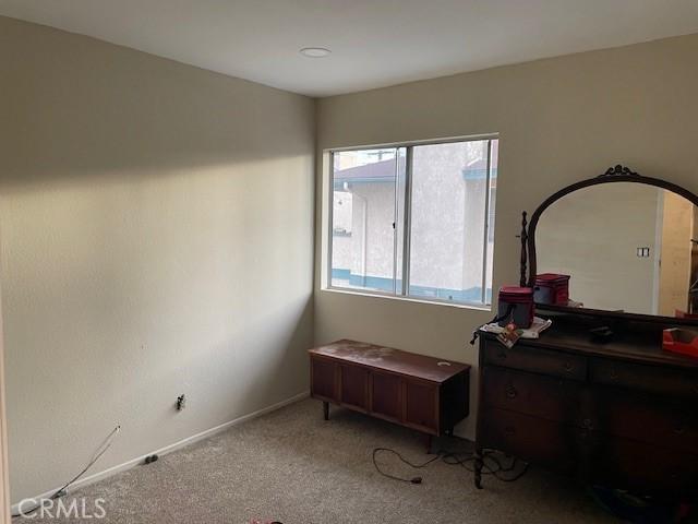 bedroom featuring light colored carpet and baseboards