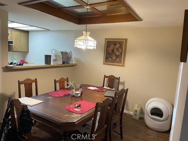 dining room with wood finished floors, visible vents, baseboards, and coffered ceiling