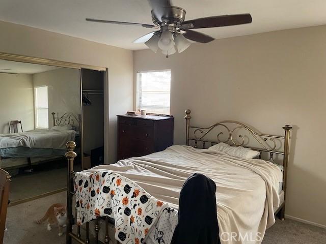 carpeted bedroom featuring a ceiling fan, baseboards, and a closet