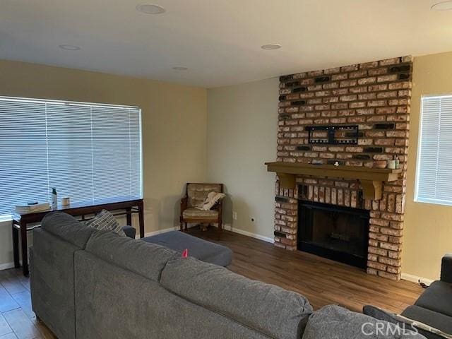living room with baseboards, wood finished floors, and a fireplace