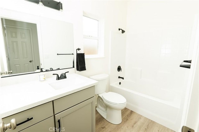 bathroom with shower / tub combination, wood finished floors, vanity, and toilet
