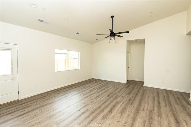 spare room with baseboards, wood finished floors, visible vents, and a ceiling fan