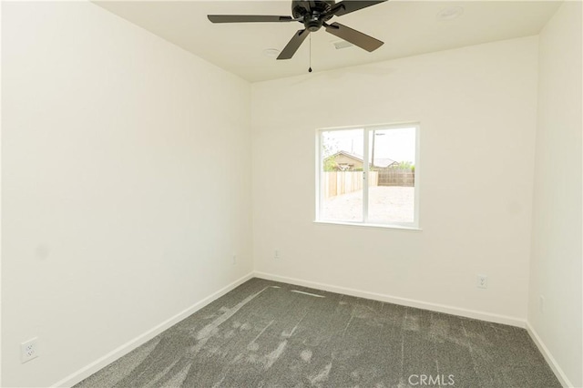 unfurnished room with dark carpet, baseboards, and a ceiling fan
