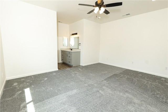 unfurnished bedroom with dark colored carpet, visible vents, a ceiling fan, and baseboards