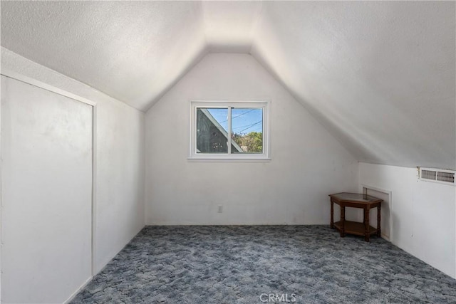bonus room with vaulted ceiling, visible vents, carpet floors, and a textured ceiling