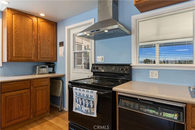 kitchen with brown cabinets, extractor fan, light wood-type flooring, and black appliances