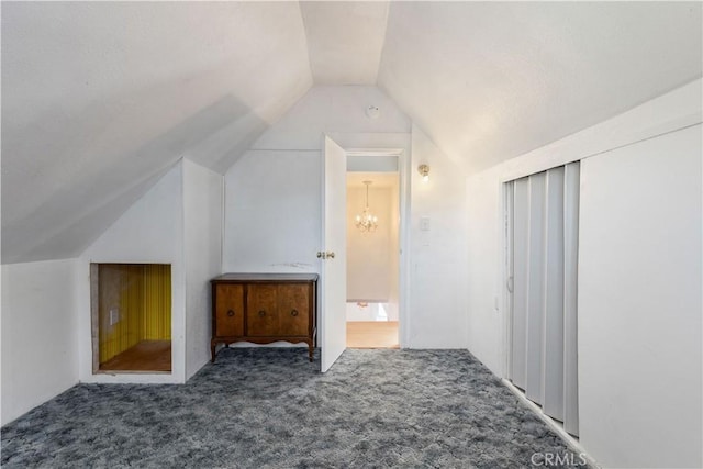 bonus room with lofted ceiling, an inviting chandelier, and carpet