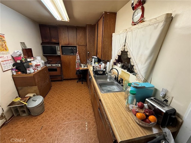4914 3rd Ave, Los Angeles, CA 90043 - kitchen with stainless steel appliances, a sink, light countertops, and light flooring