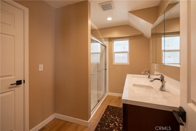 full bath with a shower stall, wood finished floors, visible vents, a sink, and baseboards