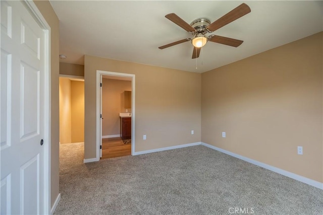 unfurnished bedroom with baseboards, carpet flooring, and ensuite bathroom