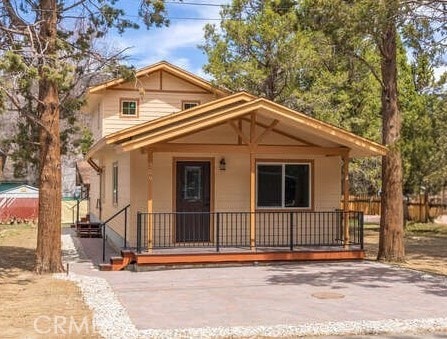 view of front of house featuring fence and a porch