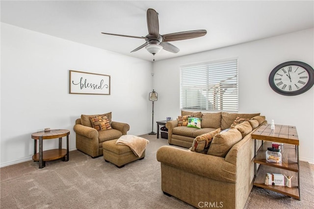 carpeted living area featuring baseboards and ceiling fan