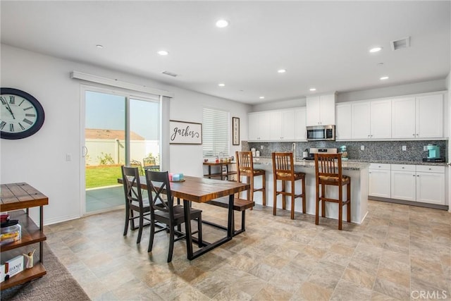 dining space with recessed lighting, visible vents, and stone finish flooring