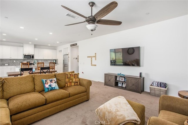 living room featuring recessed lighting, visible vents, light colored carpet, and ceiling fan