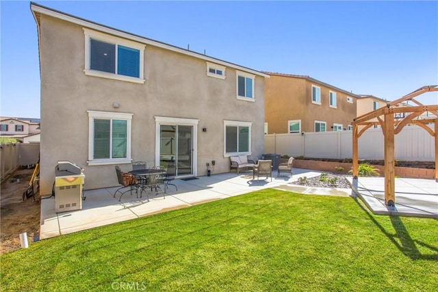 rear view of house featuring a yard, a fenced backyard, a patio, and stucco siding
