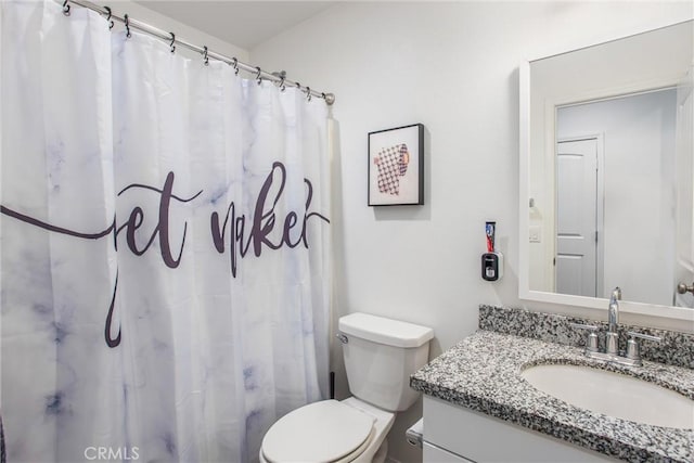 bathroom with toilet, vanity, and a shower with curtain