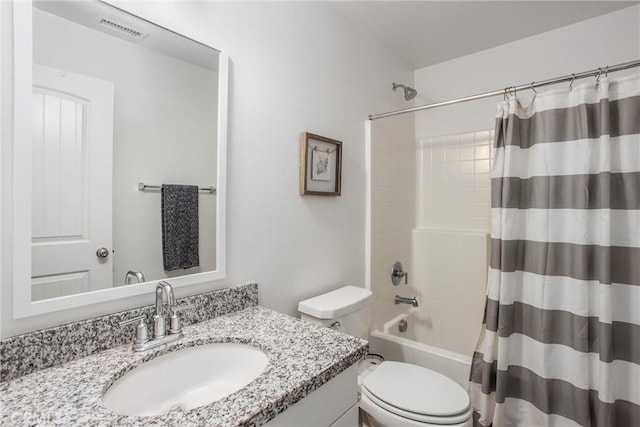 bathroom featuring visible vents, toilet, vanity, and shower / tub combo
