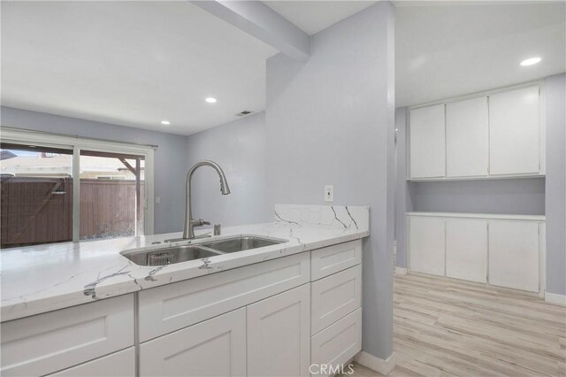13261 Coast St, Garden Grove, CA 92844 - kitchen featuring a sink, white cabinetry, light stone counters, light wood finished floors, and recessed lighting