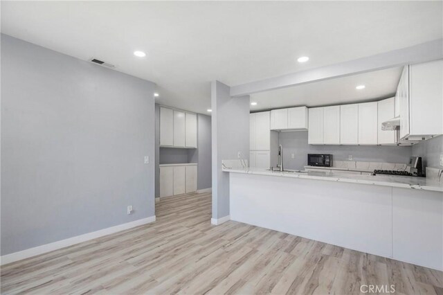 13261 Coast St, Garden Grove, CA 92844 - kitchen featuring black microwave, under cabinet range hood, stove, light wood finished floors, and recessed lighting