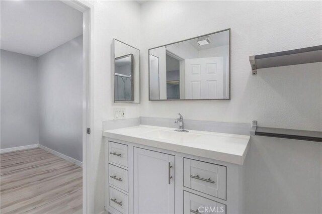 13261 Coast St, Garden Grove, CA 92844 - bathroom featuring vanity, wood finished floors, and baseboards