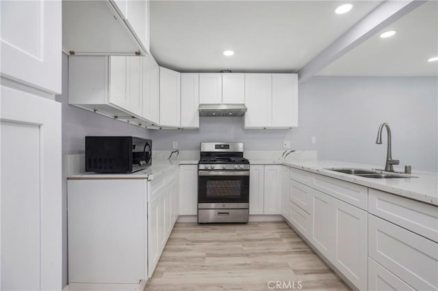 13261 Coast St, Garden Grove, CA 92844 - kitchen with stainless steel gas range oven, under cabinet range hood, black microwave, a sink, and light stone counters