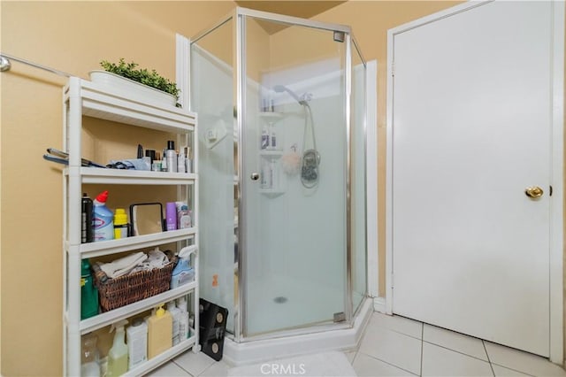 full bath featuring tile patterned floors and a shower stall