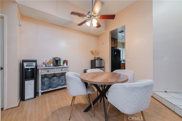 dining area featuring baseboards, a ceiling fan, visible vents, and light wood-style flooring