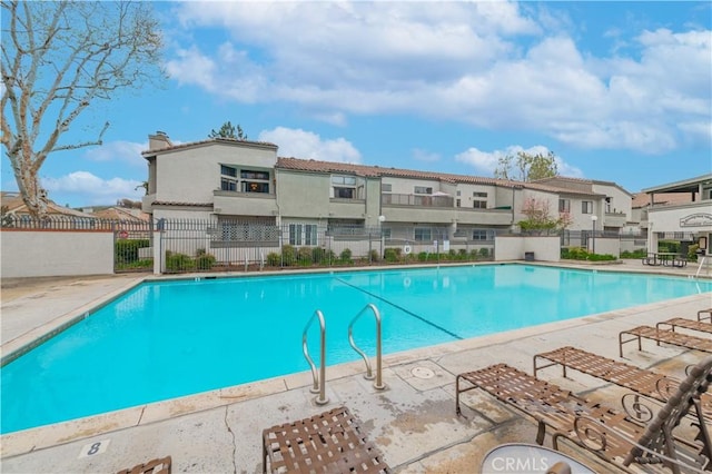 pool with fence, a residential view, and a patio