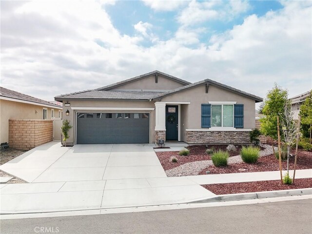 view of front of property featuring fence, concrete driveway, an attached garage, stucco siding, and stone siding