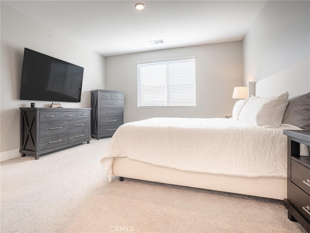 bedroom with baseboards, visible vents, and light colored carpet