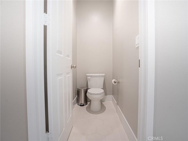 bathroom with tile patterned flooring, toilet, and baseboards
