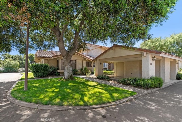 view of front facade with a tiled roof, a front lawn, and stucco siding