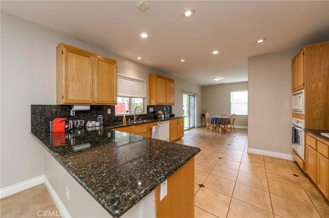 kitchen featuring recessed lighting, tasteful backsplash, baseboards, and white appliances