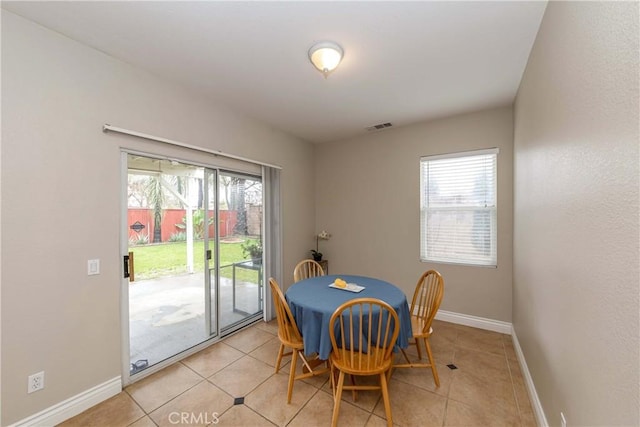 dining space featuring baseboards, visible vents, a wealth of natural light, and light tile patterned flooring