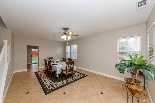 dining space with baseboards, a ceiling fan, visible vents, and light tile patterned floors
