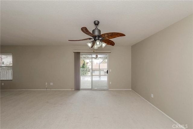unfurnished room featuring baseboards, ceiling fan, and light colored carpet