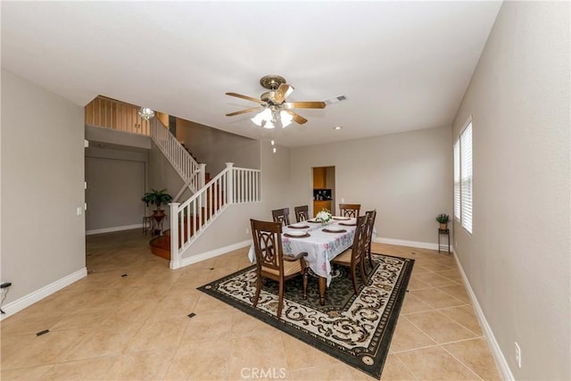 dining area with stairway, visible vents, light tile patterned floors, baseboards, and ceiling fan