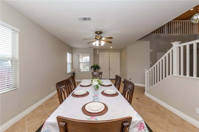 dining area with baseboards, a ceiling fan, visible vents, and light tile patterned floors