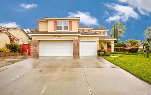 view of front of home featuring a garage, a front yard, concrete driveway, and stucco siding
