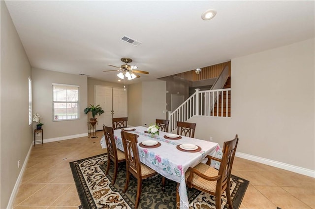 dining room featuring stairway, visible vents, light tile patterned flooring, baseboards, and ceiling fan