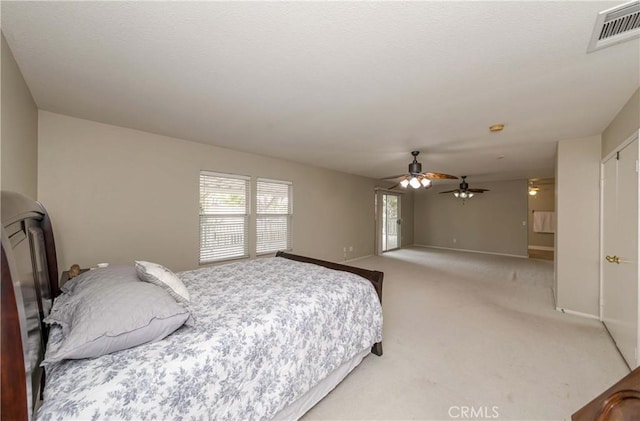 bedroom featuring visible vents, a ceiling fan, baseboards, and light carpet