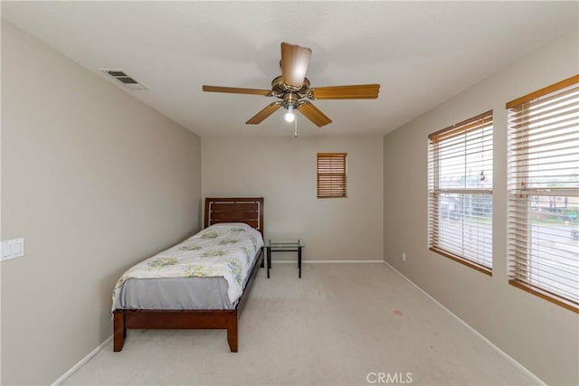 bedroom featuring visible vents, baseboards, and light carpet