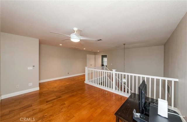 unfurnished room with ceiling fan, baseboards, visible vents, and light wood finished floors