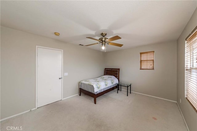 bedroom with ceiling fan, baseboards, and light colored carpet